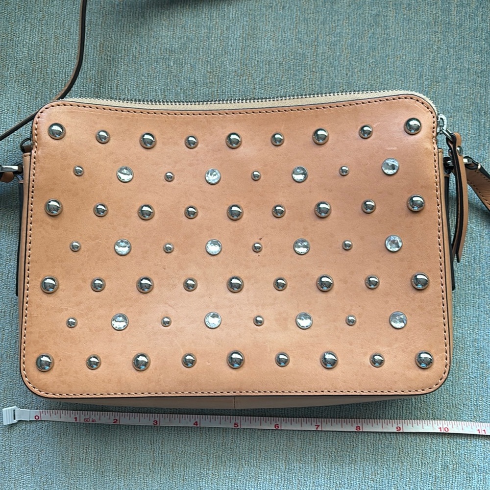 Cross body or shoulder bag. 100% leather. Tan. Silver/rhinestone accents.